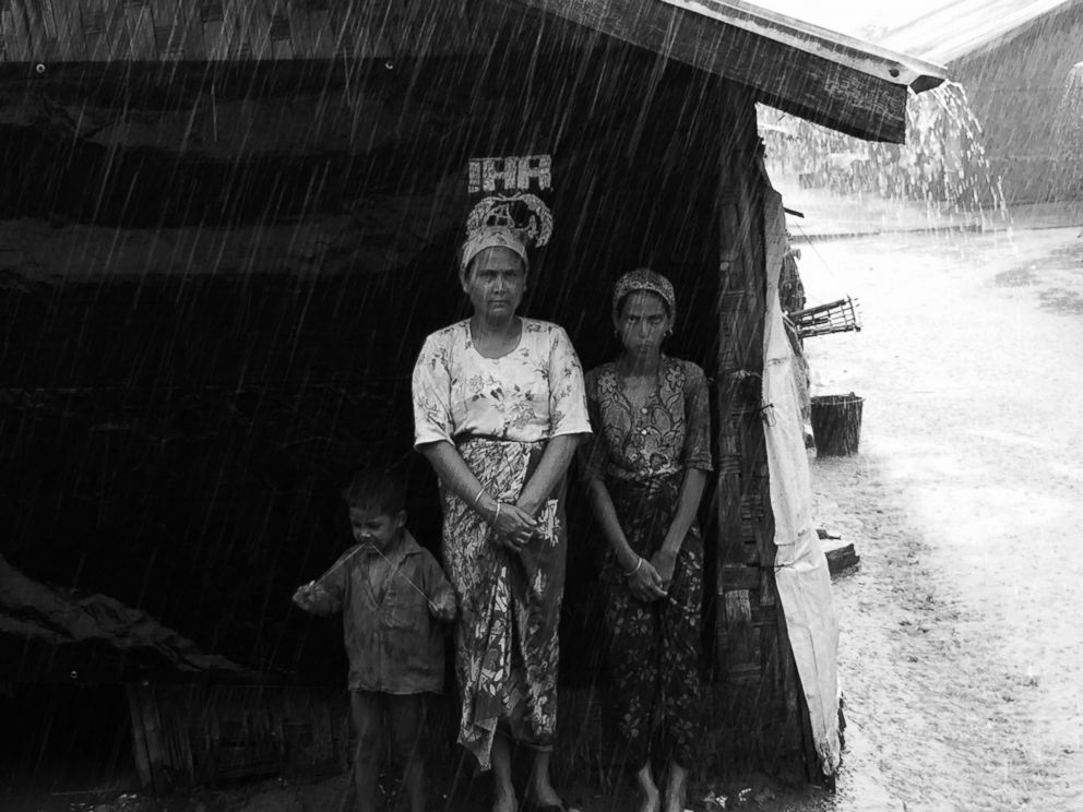 PHOTO: Rohingya women are pictured in a refugee camp on the outskirts of Sittwe, Myanmar, waiting for the rain to stop. 