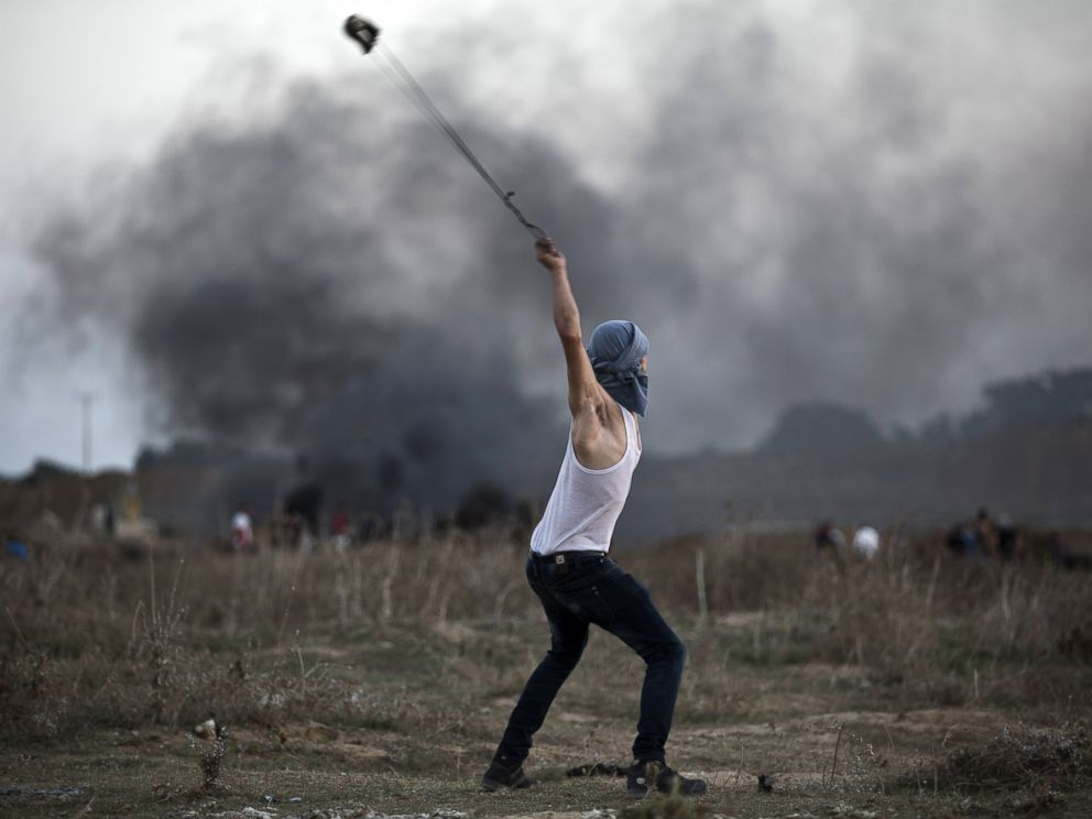 PHOTO: A Palestinian protester uses a slingshot to throw stones towards Israeli soldiers during clashes near the border fence between Israel and the central Gaza Strip east of Bureij on Oct. 15, 2015. 