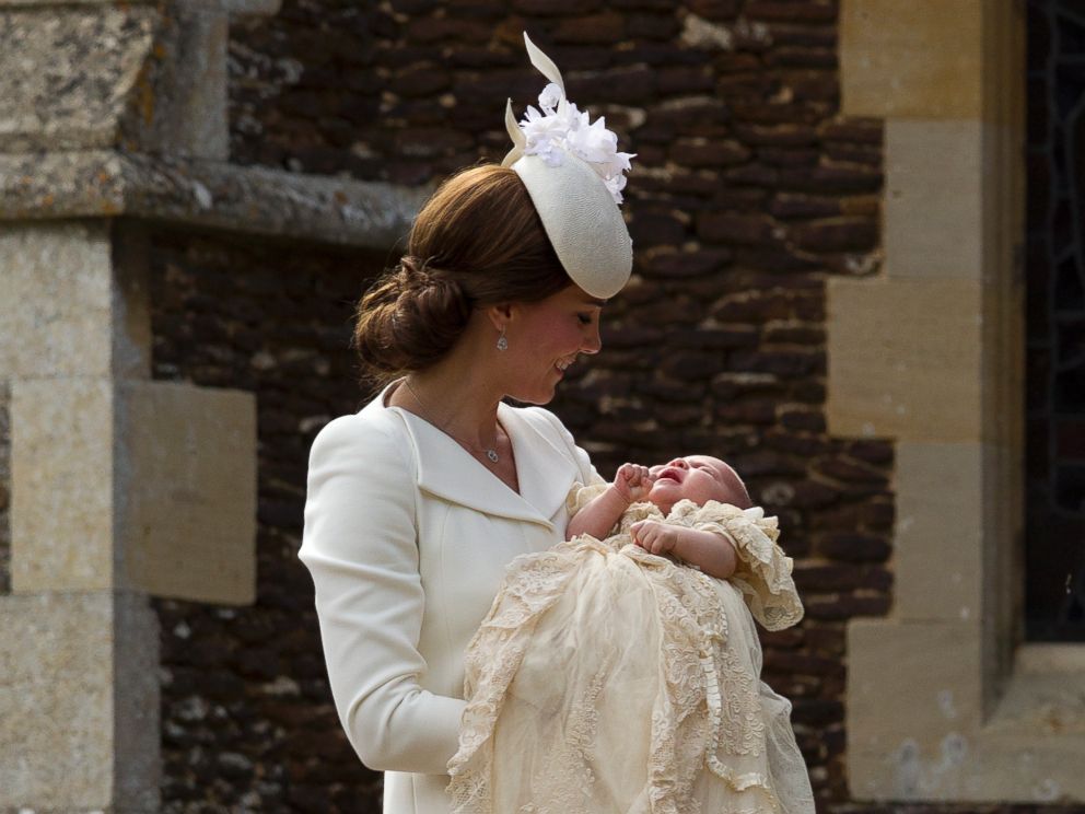 PHOTO: Britains Kate the Duchess of Cambridge carries Princess Charlotte after taking her out of a pram as they arrive for Charlottes Christening at St. Mary Magdalene Church in Sandringham, England, July 5, 2015.