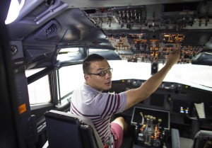 Guest sits in Boeing 747 Restaurant Cockpit for a photo