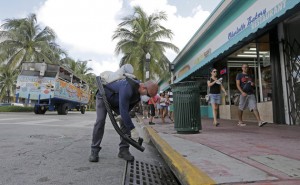 Miami-Dade mosquito control inspector Yasser "Jazz" Compagines sprays a chemical mist into a storm drain, as a tour vessel passes by at left, Tuesday, Aug. 23, 2016, in Miami Beach, Fla. Gov. Rick Scott has announced that the Florida Department of Health is allocating another $5 million in funding to Miami-Dade County for Zika preparedness and mosquito control. Zika fears are leading some to book away from the Caribbean and Florida. The American Southwest, New England and Bermuda are providing a virus-free alternative, but destinations are hesitant to market themselves as such. (AP Photo/Alan Diaz)